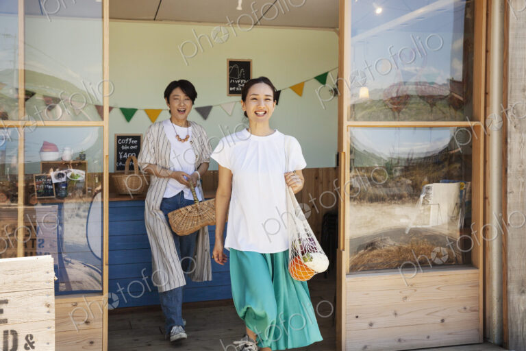 Two smiling Japanese women leaving farm shop.