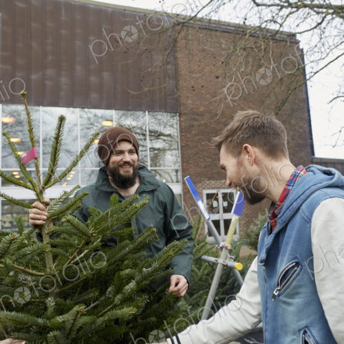 Two staff and a woman client looking at a large Christmas tree. Two staff and a woman client looking at a large Christmas tree.