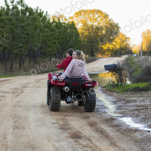 Two teenagers riding on a buggy, all terrain vehicle on a muddy track. Two teenagers riding on a buggy, all terrain vehicle on a muddy track.