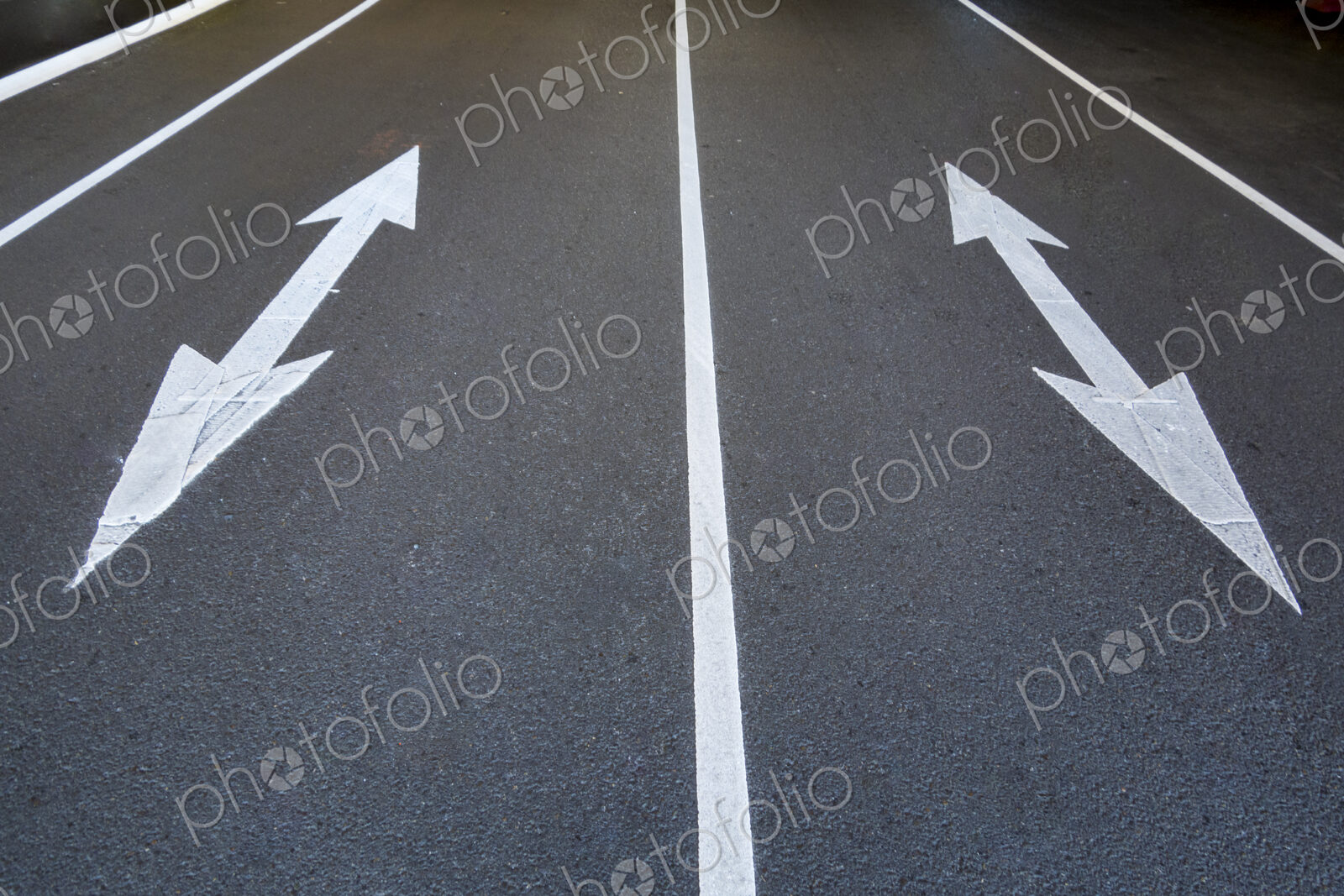 Two traffic arrow symbols on the road surface, pointed at both ends, on a city road in…