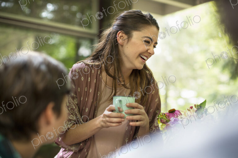 Two woman at a table talking and laughing.