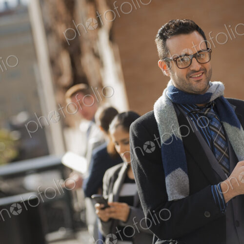 Two women and two men on the sidewalk. Two people checking their mobile phones. Two women and two men on the sidewalk. Two people checking their mobile phones.
