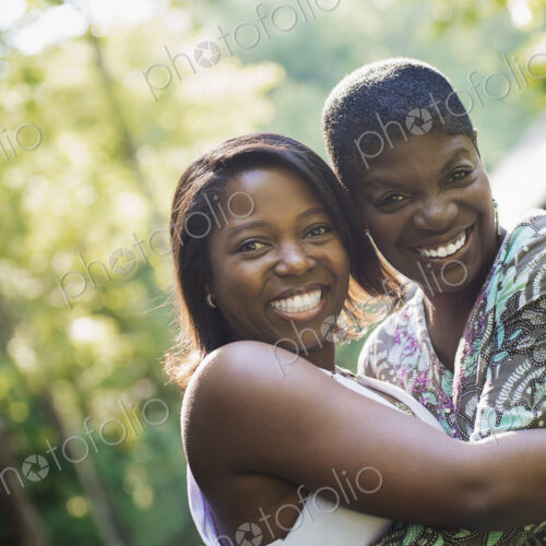 Two women embracing each other and laughing. Two women embracing each other and laughing.