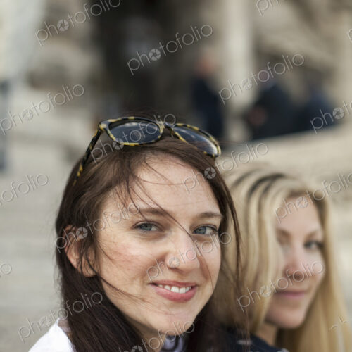 Two women in the street in the historic city of Rome. A blonde haired woman and a…