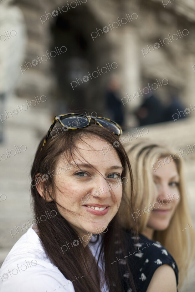 Two women in the street in the historic city of Rome. A blonde haired woman and a…