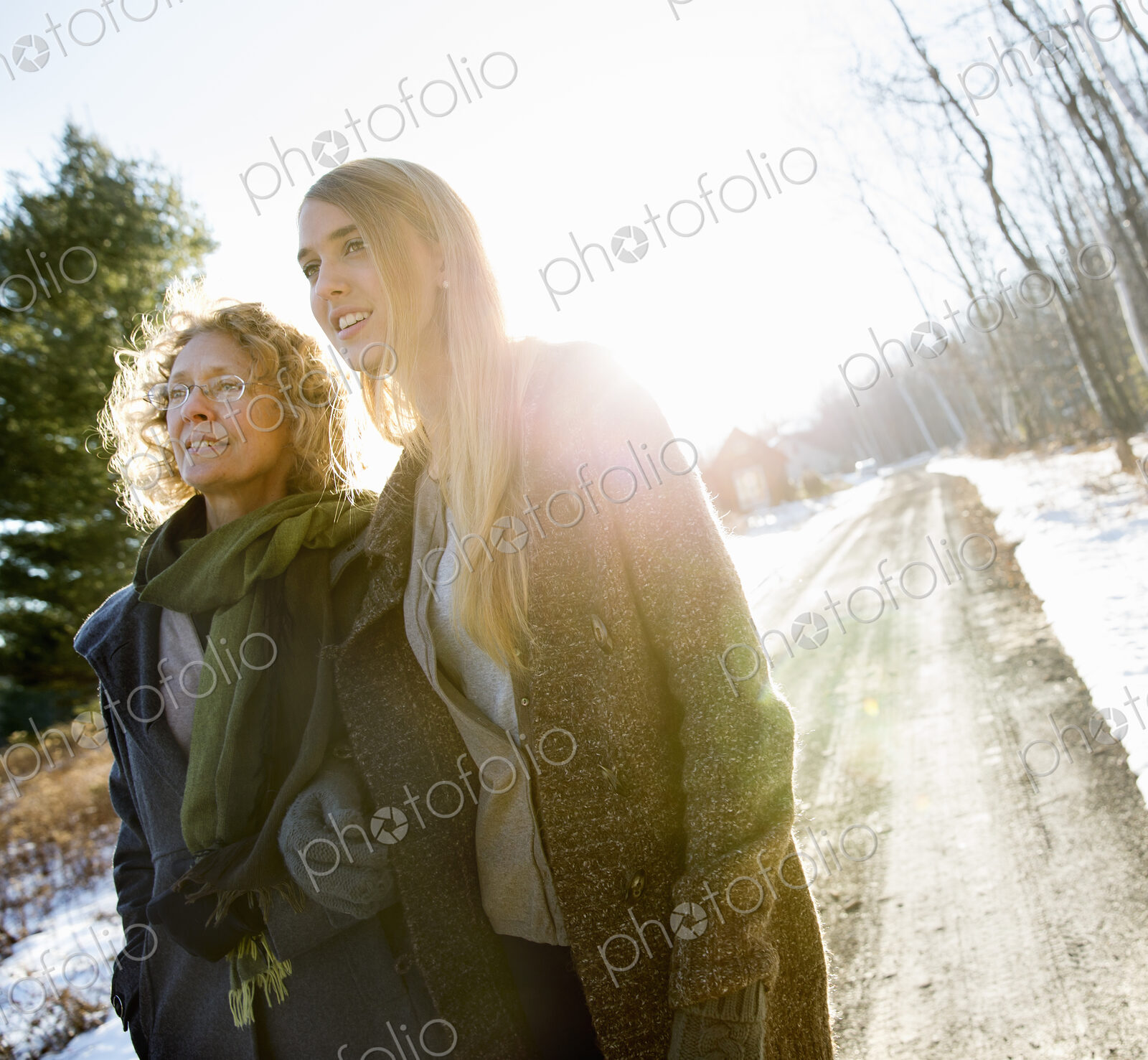 Two women, mother and adult daughter outdoors on a winter’s day, snow on the ground.