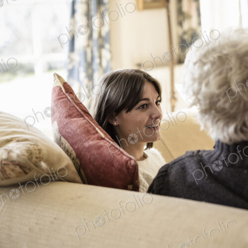 Two women, mother and daughter, sitting side by side, laughing. Two women, mother and daughter, sitting side by side, laughing.