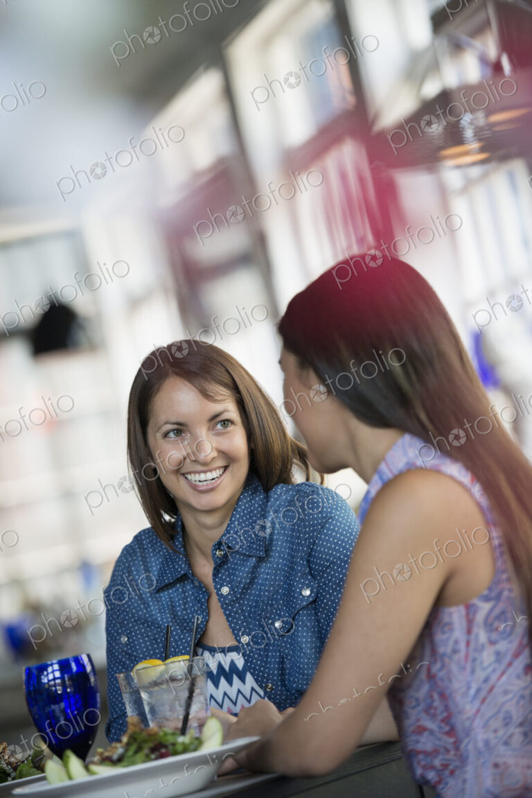 Two women seated at a cafe table having a meal.