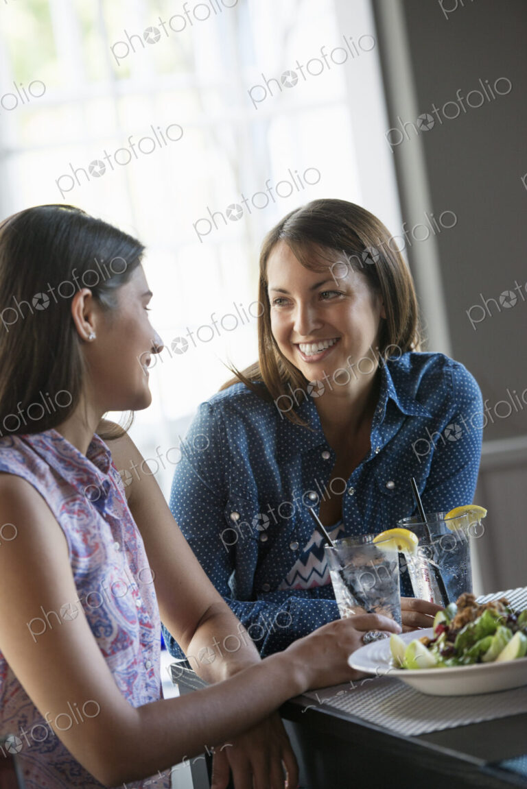 Two women seated at a cafe table having a meal.