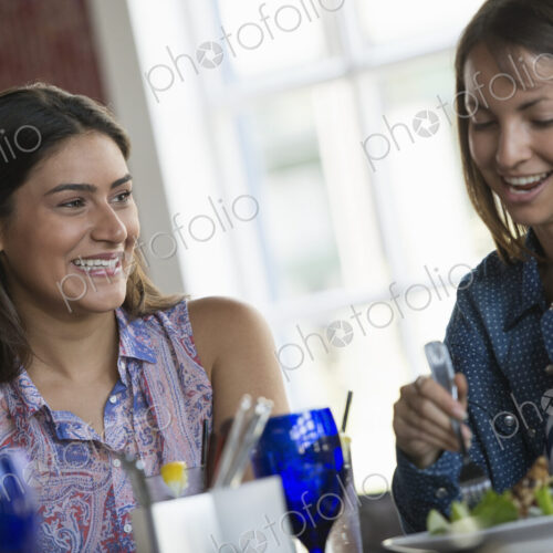 Two women seated at a cafe table having a meal.