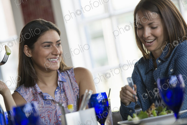 Two women seated at a cafe table having a meal.