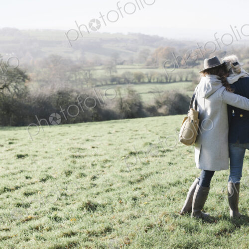 Two women side by side on a grass slope overlooking the landscape of Dorset. Two women side by side on a grass slope overlooking the landscape of Dorset.