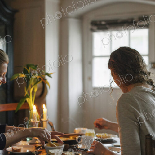 Two women sitting at a table having a meal by candlelight. Two women sitting at a table having a meal by candlelight.