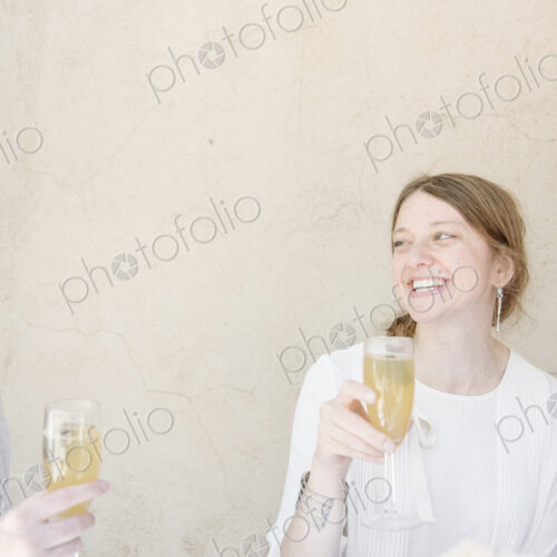 Two women sitting at a table, smiling at each other, holding glasses of champagne.
