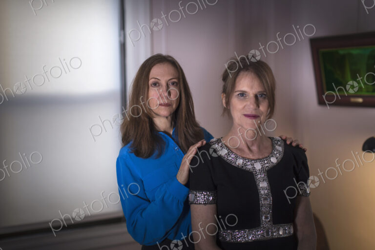Two women standing, one behind the other.