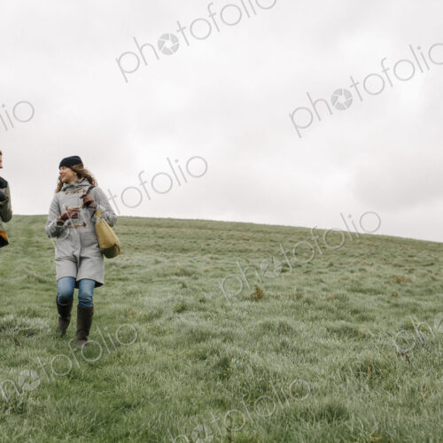 Two women walking across grass. Two women walking across grass.