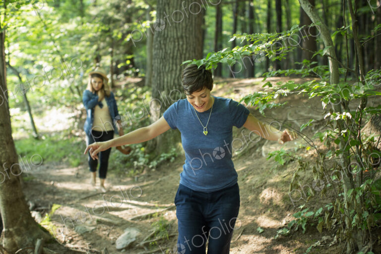 Two women walking down a woodland path.