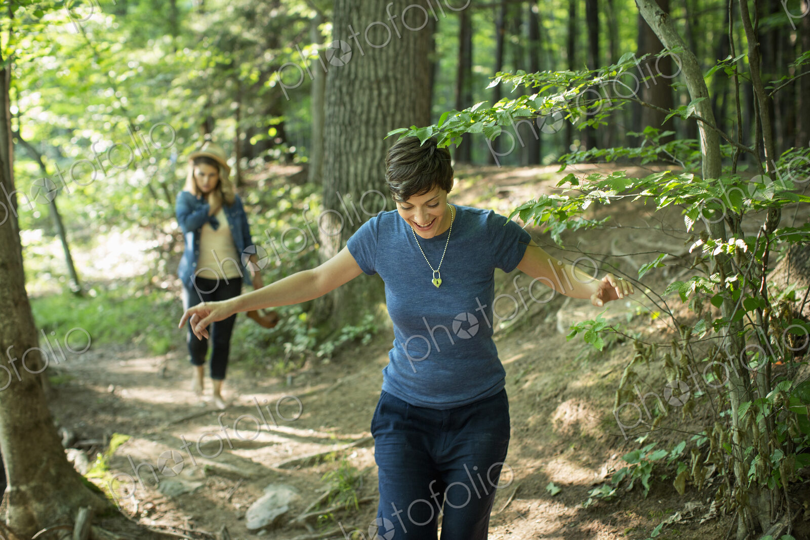 Two women walking down a woodland path.
