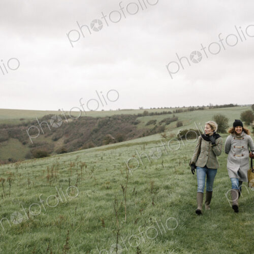Two women walking on a country path across grassland. Two women walking on a country path across grassland.