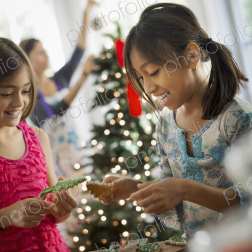 Two young girls decorating organic Christmas cookies. Two young girls decorating organic Christmas cookies.