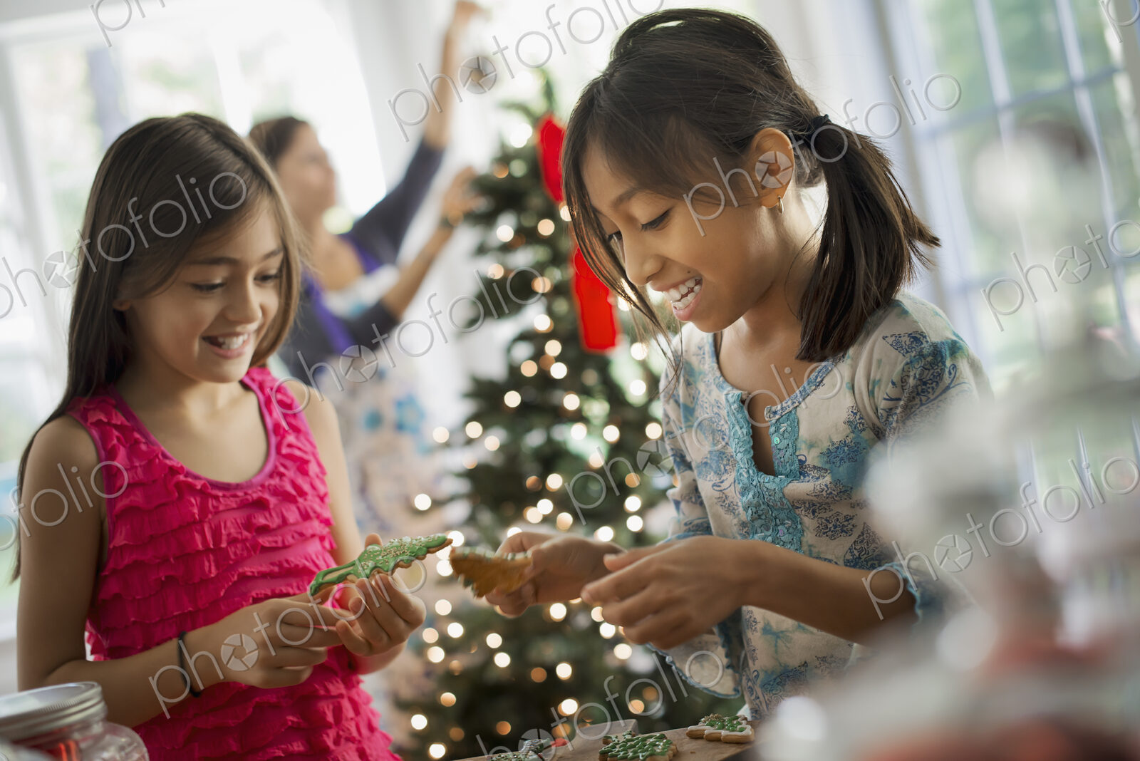 Two young girls decorating organic Christmas cookies.