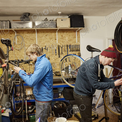 Two young men in a cycle shop, talking.