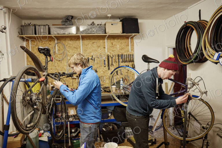 Two young men in a cycle shop, talking.