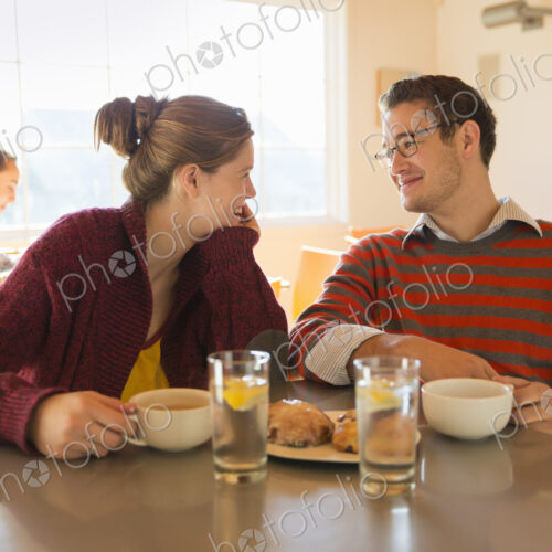 Two young people, a man and a young woman sitting at a counter in a coffee shop. Two young people, a man and a young woman sitting at a counter in a coffee shop.