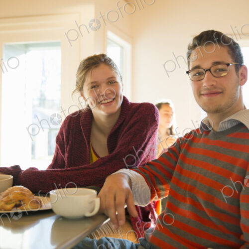 Two young people, a man and a young woman sitting at a counter in a coffee shop. Two young people, a man and a young woman sitting at a counter in a coffee shop.