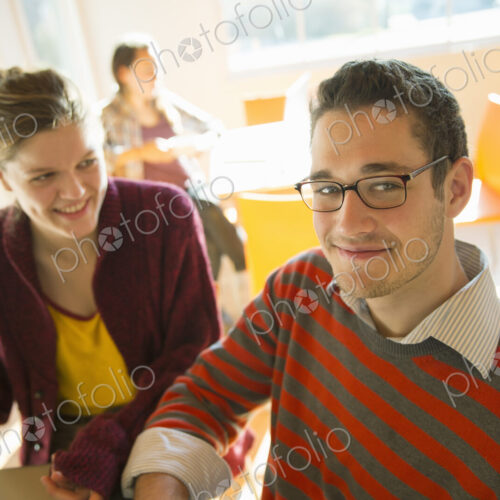 Two young people, a man and a young woman sitting at a counter in a coffee shop. Two young people, a man and a young woman sitting at a counter in a coffee shop.