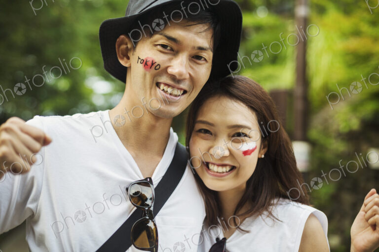 Two young people in woodland, with Japanese flags painted on their cheeks