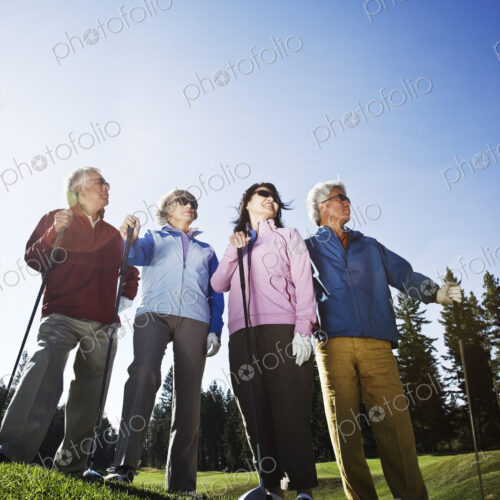 Two young senior golfing couples on the course and ready to play.