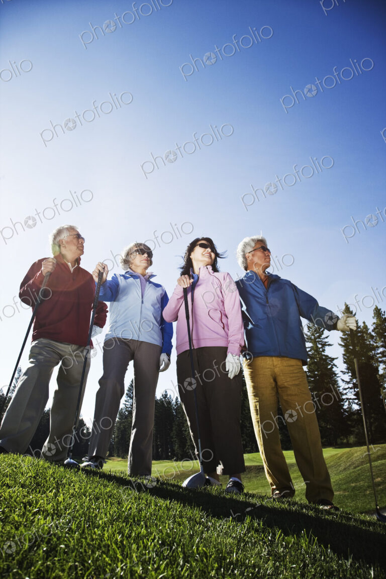 Two young senior golfing couples on the course and ready to play.