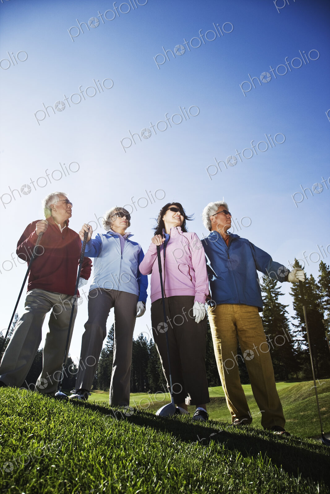 Two young senior golfing couples on the course and ready to play.