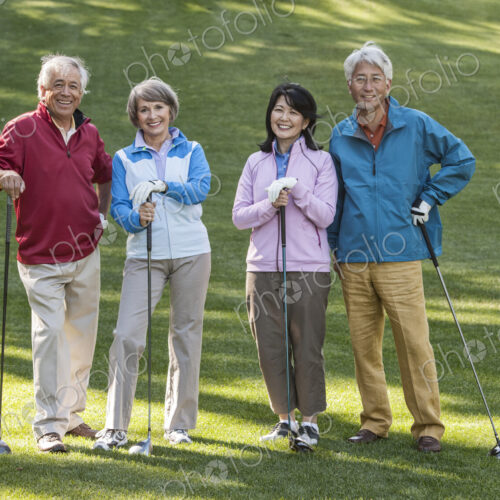 Two young senior golfing couples on the course and ready to play.