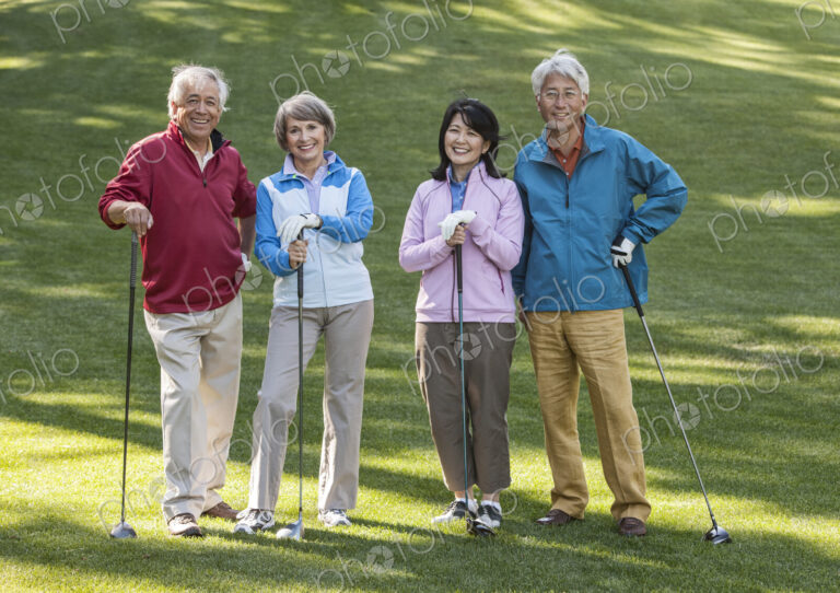 Two young senior golfing couples on the course and ready to play.