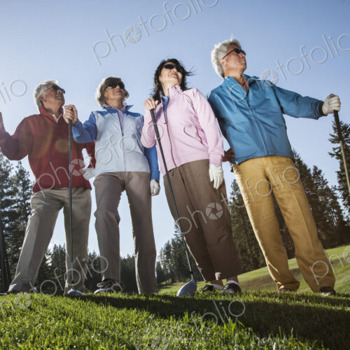 Two young senior golfing couples on the course and ready to play.