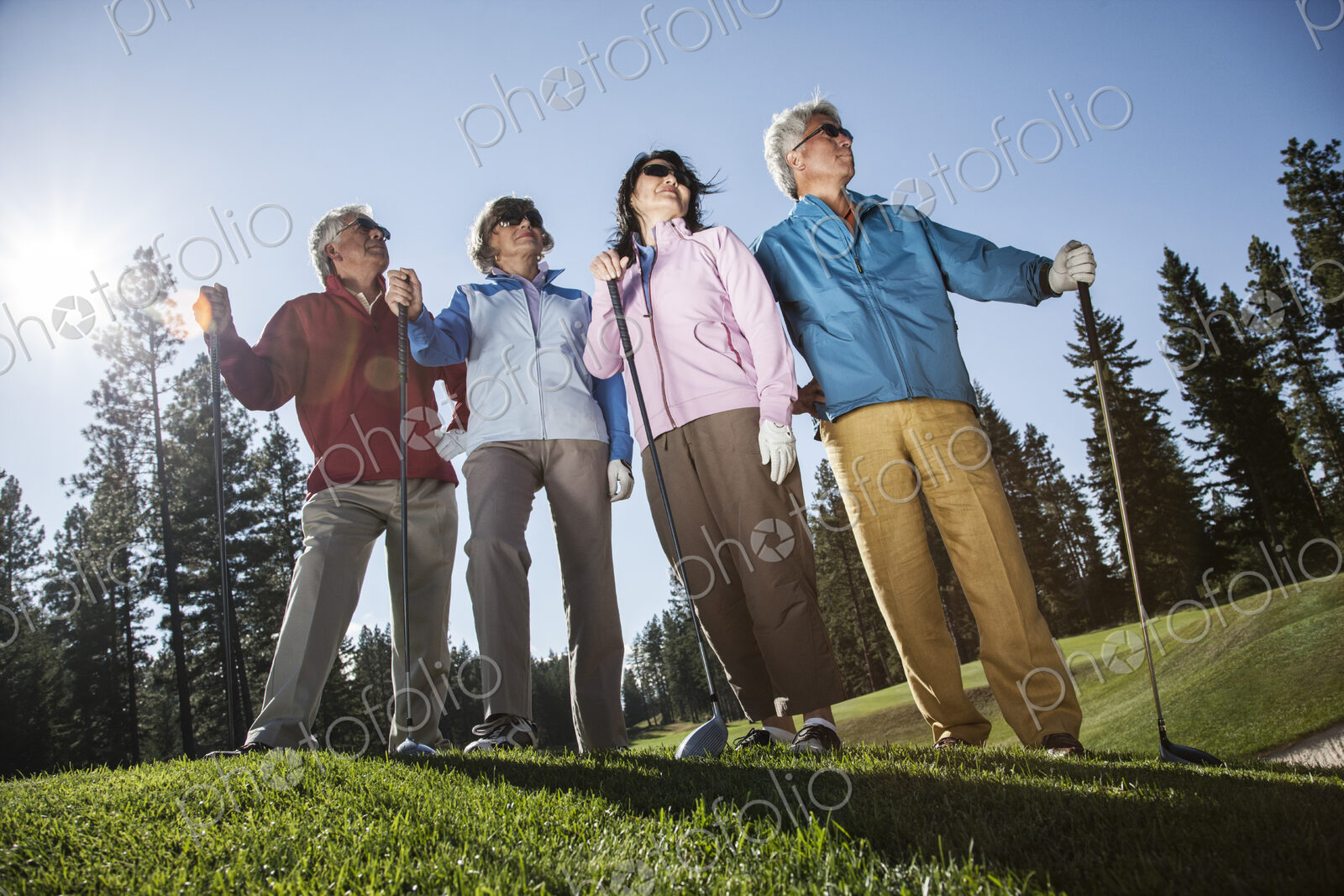 Two young senior golfing couples on the course and ready to play.
