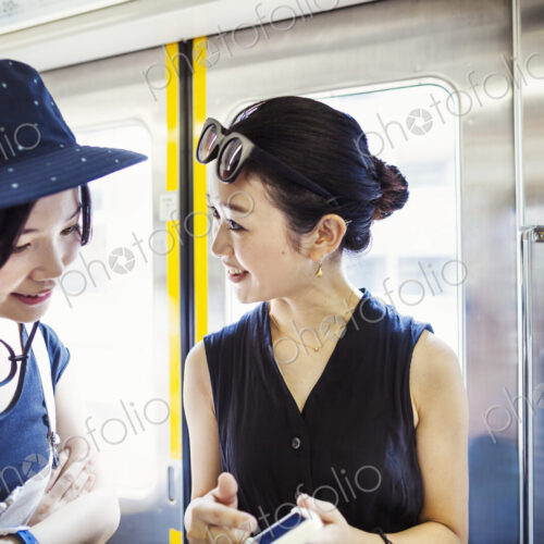 Two young woman traveling on a train.