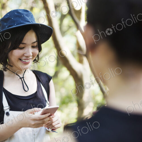 Two young women standing in a forest.