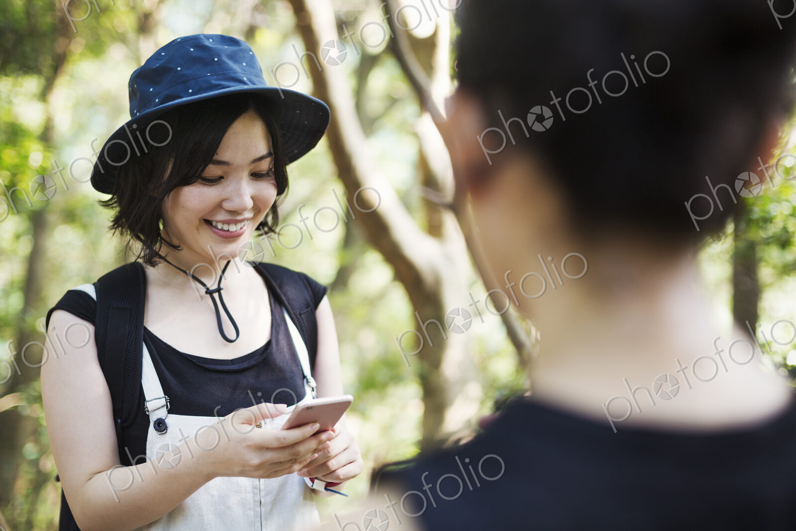 Two young women standing in a forest.