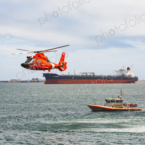 US Coast Guard helicopter hovering over the water in a demo of a rescue for a sea swimmer.
