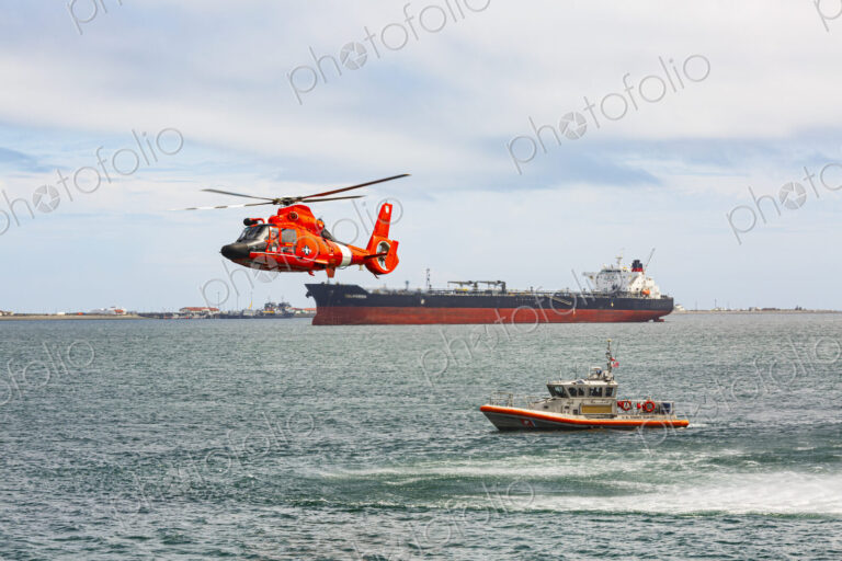 US Coast Guard helicopter hovering over the water in a demo of a rescue for a sea swimmer.
