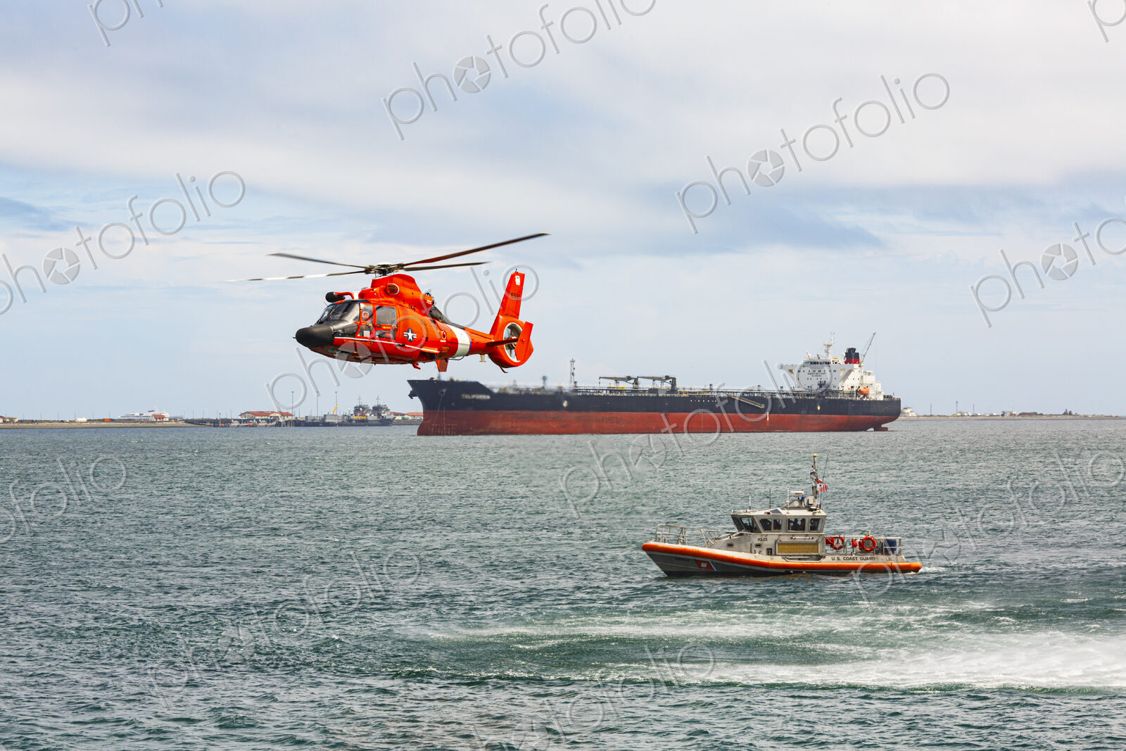 US Coast Guard helicopter hovering over the water in a demo of a rescue for a sea swimmer.
