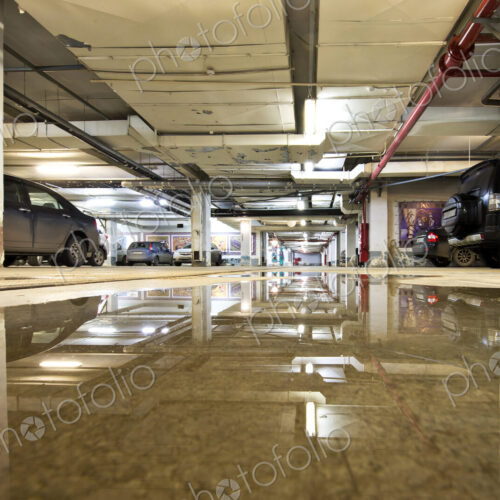 Underground parking garage in Moscow, Russia, with a large puddle on the floor.
