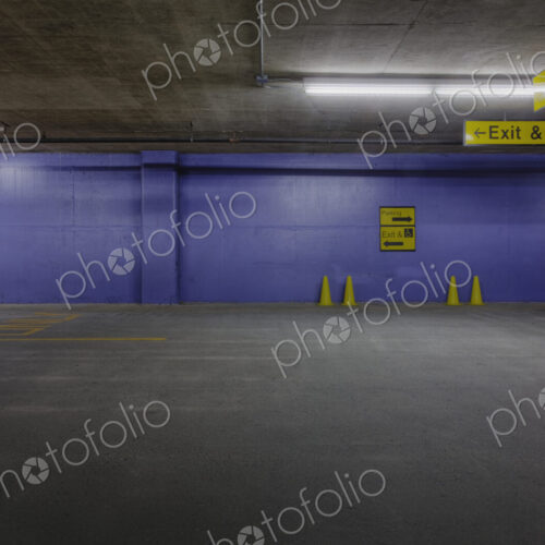 Underground parking lot with traffic cones and blue wall. Underground parking lot with traffic cones and blue wall.