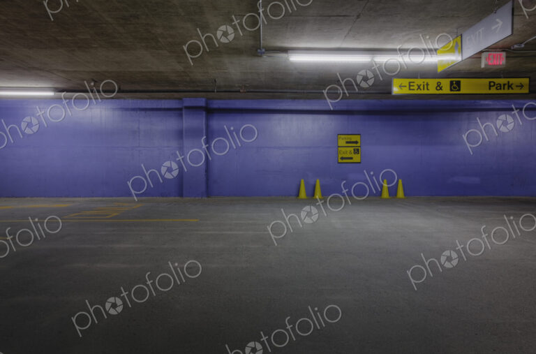 Underground parking lot with traffic cones and blue wall.