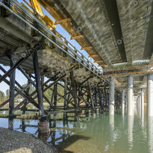 Underside of a new bridge being constructed alongside an old one.
