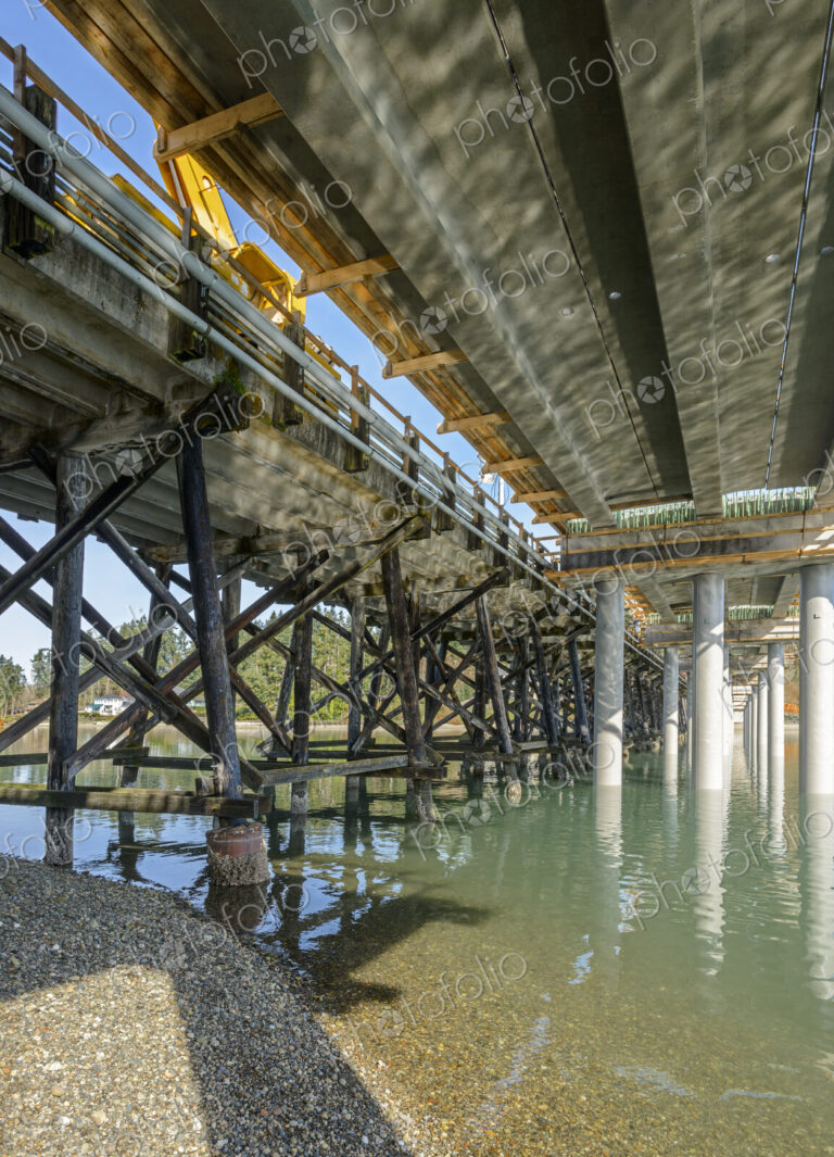 Underside of a new bridge being constructed alongside an old one.