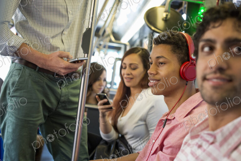 Urban Lifestyle. A group of people, men and women on a city bus, in New York city. A…